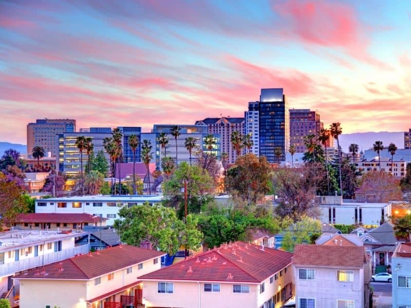 San Jose skyline at sunset with downtown buildings, palm trees, and residential neighborhoods for San Jose land surveying services